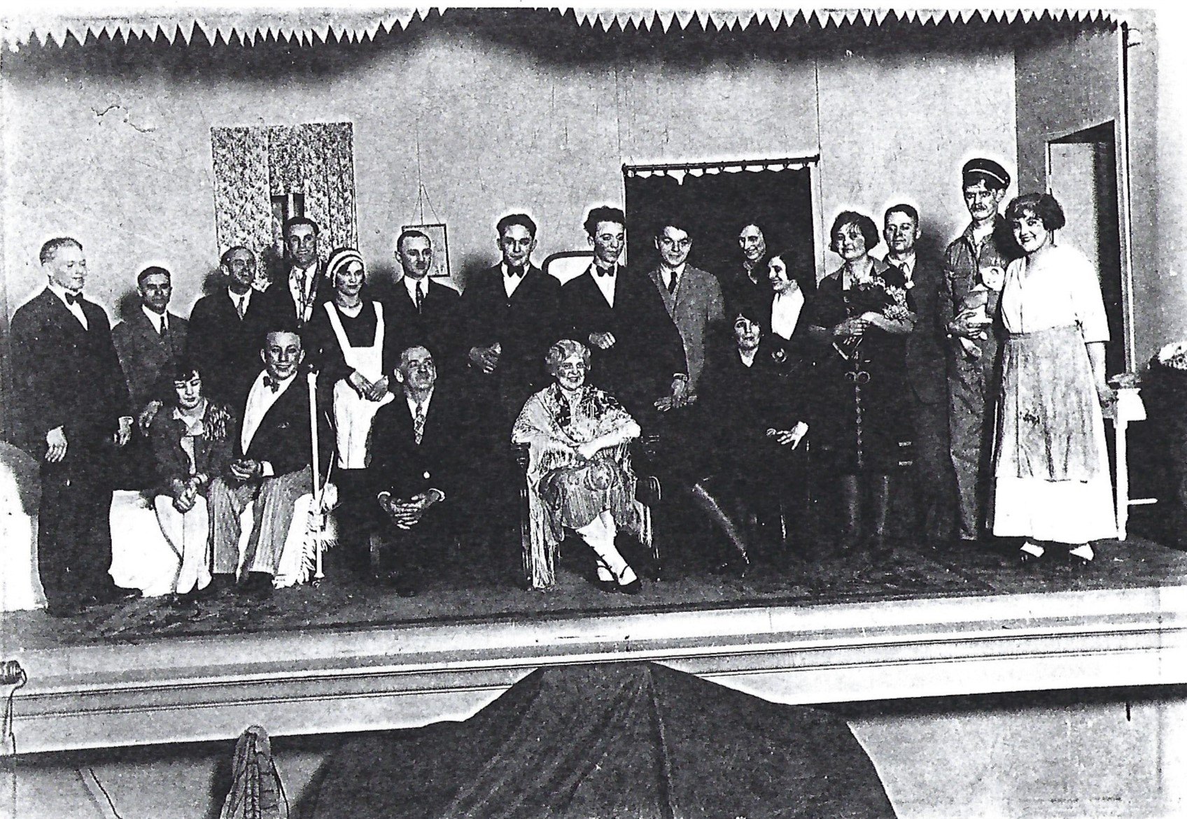 A group of 1930s amatuer actors and actresses on Heights Theater's historic stage. Photo is black and white.